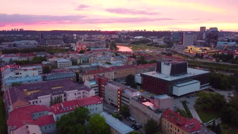 drone slowly flies forward, beautiful aerial view, cityscape of vilnius, lithuania, at dusk