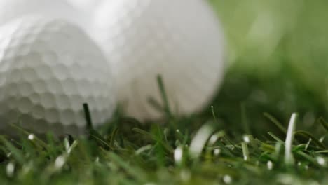 close up of golf balls on grass, copy space, slow motion