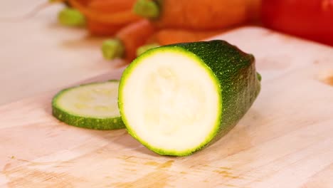 manos cortando pepino con tomates y zanahorias cerca