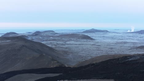 dark black rock flowing downhill from inactive geldingadalsgos volcano, iceland