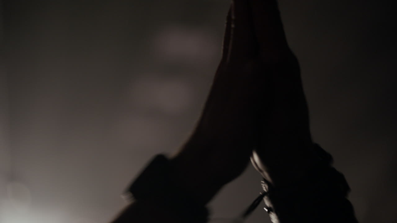 Dramatic Silhouette of Hands Moving in Smoky Light