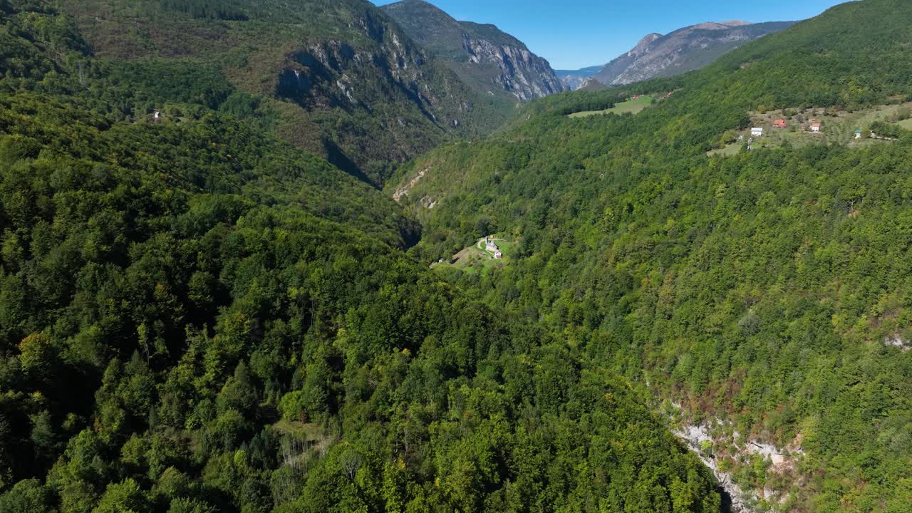 Establishing drone shot of Tara River Canyon with green forest in the day in Montenegro