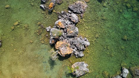 Aerial-flyover-large-boulders-in-lake-huron-coastline,-Michigan