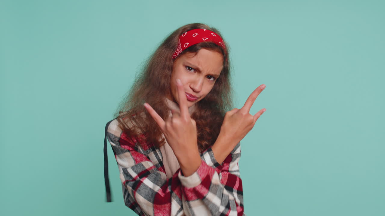 una adolescente muy feliz, una niña, un niño, un espectáculo de rock and roll, un gesto con las manos, bailando, regocijándose en el éxito