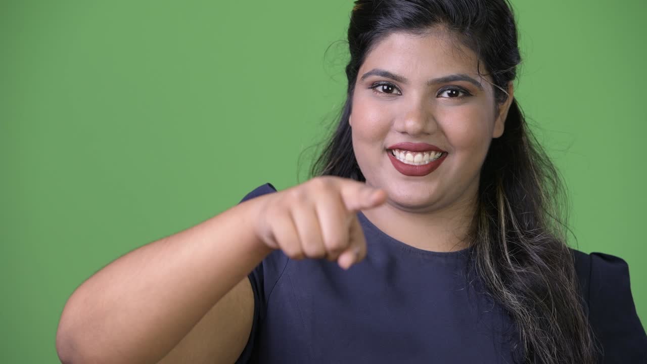 joven sobrepeso hermosa mujer de negocios india contra fondo verde