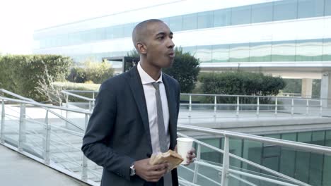 businessman eating sandwich on street