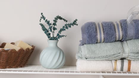 organized bathroom shelf with towels and decor