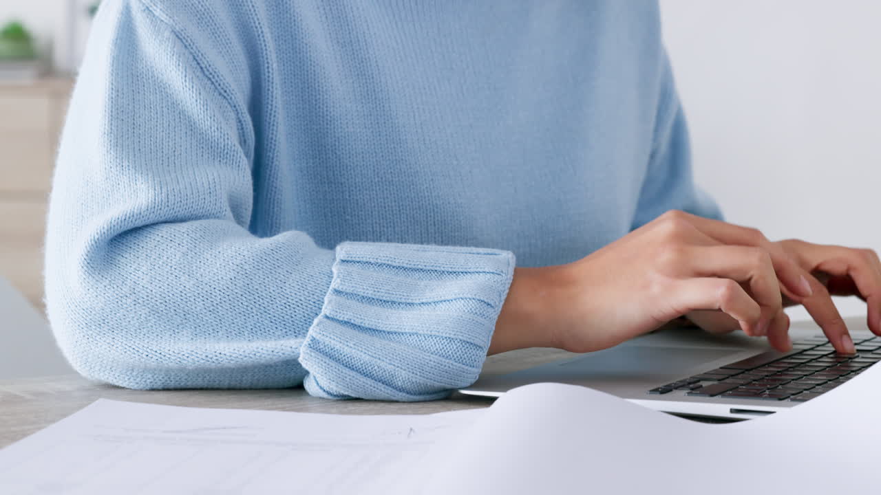 Documents, hands and laptop at an office typing