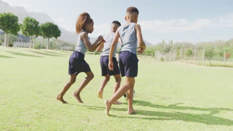 Video-Von-Drei-Afroamerikanischen-Schulkindern,-Die-Barfuß-Auf-Dem-Feld-Fußball-Spielen