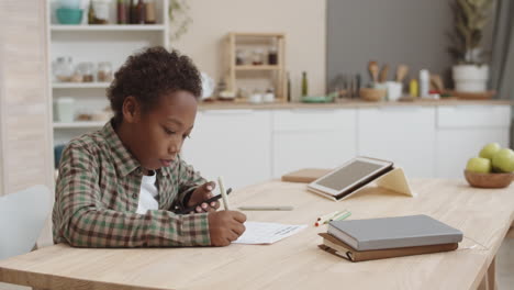 child doing homework in kitchen