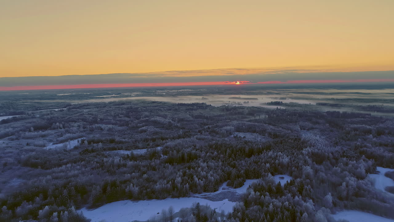 Red sunset or sunrise over harsh winter landscape, aerial drone view