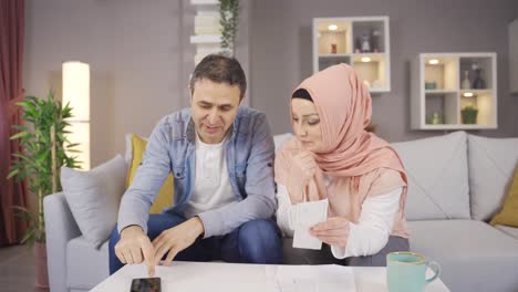 Muslim-couple-calculating-household-budget-and-debt-bills.