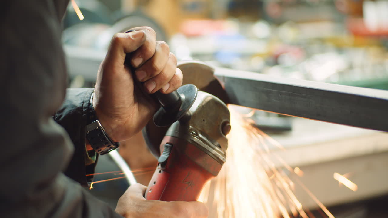 hombre de la industria del acero que usa una amoladora angular para moler objetos metálicos en el taller 1