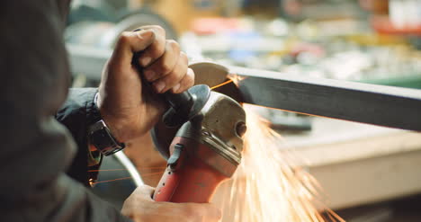 steel industry man using angle grinder grinding metal object at workshop 1