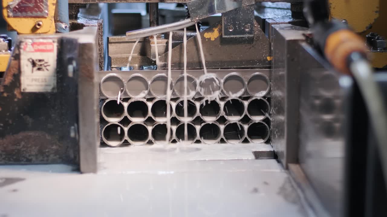 Cutting stainless steel pipes, the band saw for industrial cutting the metal stainless pipe and using the coolant heating.The industrial tool.