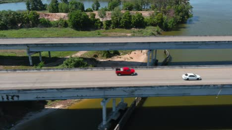 Antena-De-Autos-Circulando-Por-El-Puente-Que-Cruza-El-Río-San-Jacinto-En-Houston,-Texas