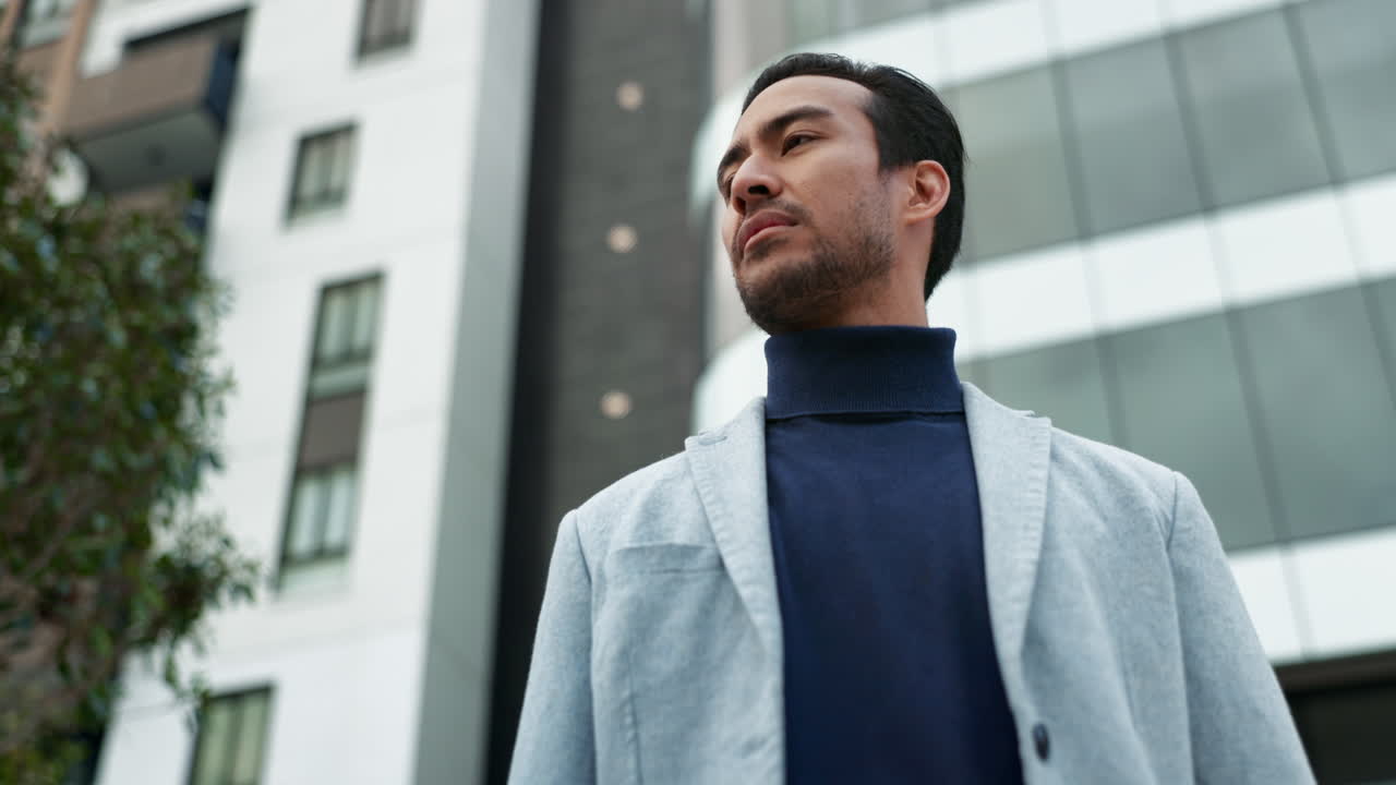 도시 의 건물 을 바라보는 슈트 를 입은 남자