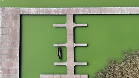 fishing platforms on stilts by a lake in northern greece | top down shot of a fishing platform in green murky water