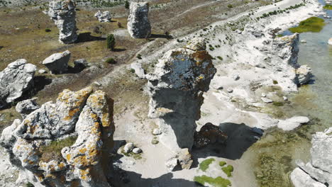 antena girando alrededor de la vista de drones a vista de pájaro del mar báltico en calma y de una interesante formación rocosa en la costa de la isla de gotland