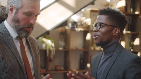 diverse male colleagues using tablet and speaking