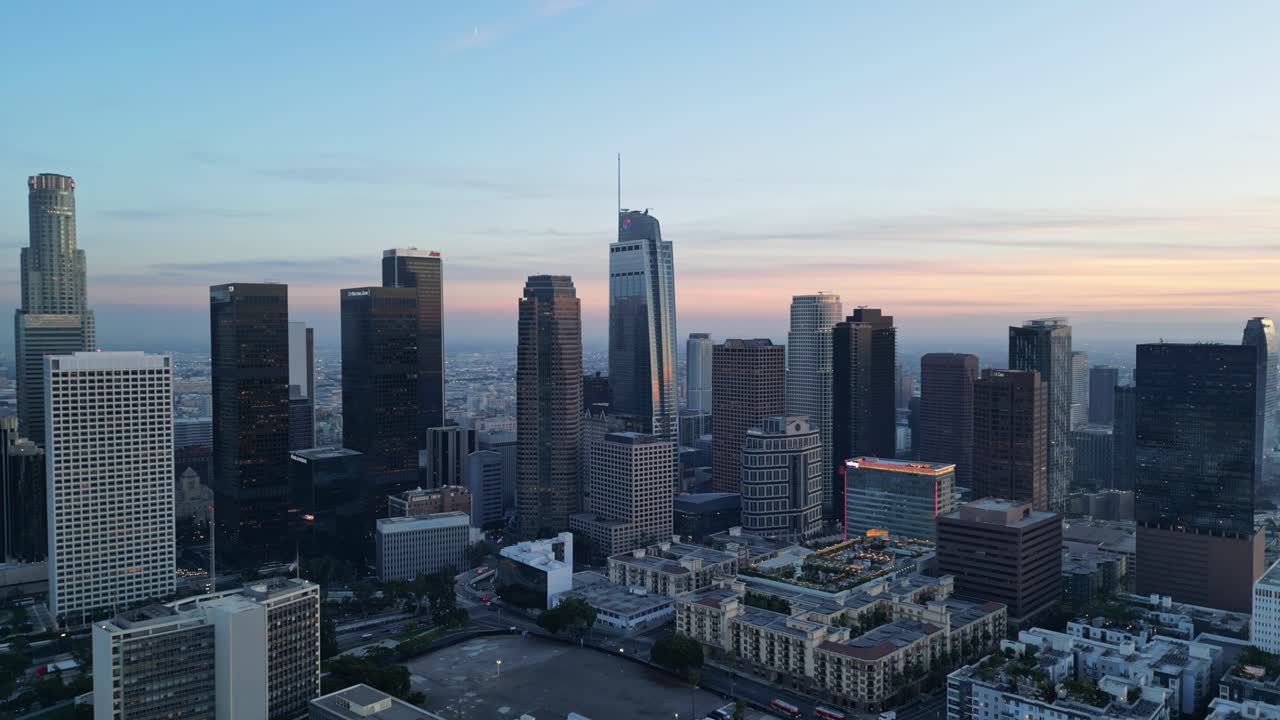 A drone shot capturing the stunning Los Angeles skyscrapers silhouetted against a vibrant sunset sky.