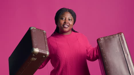 woman grasping two pieces of luggage