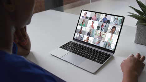 mujer afroamericana hablando en videoconferencia en computadora portátil con colegas de oficina en casa