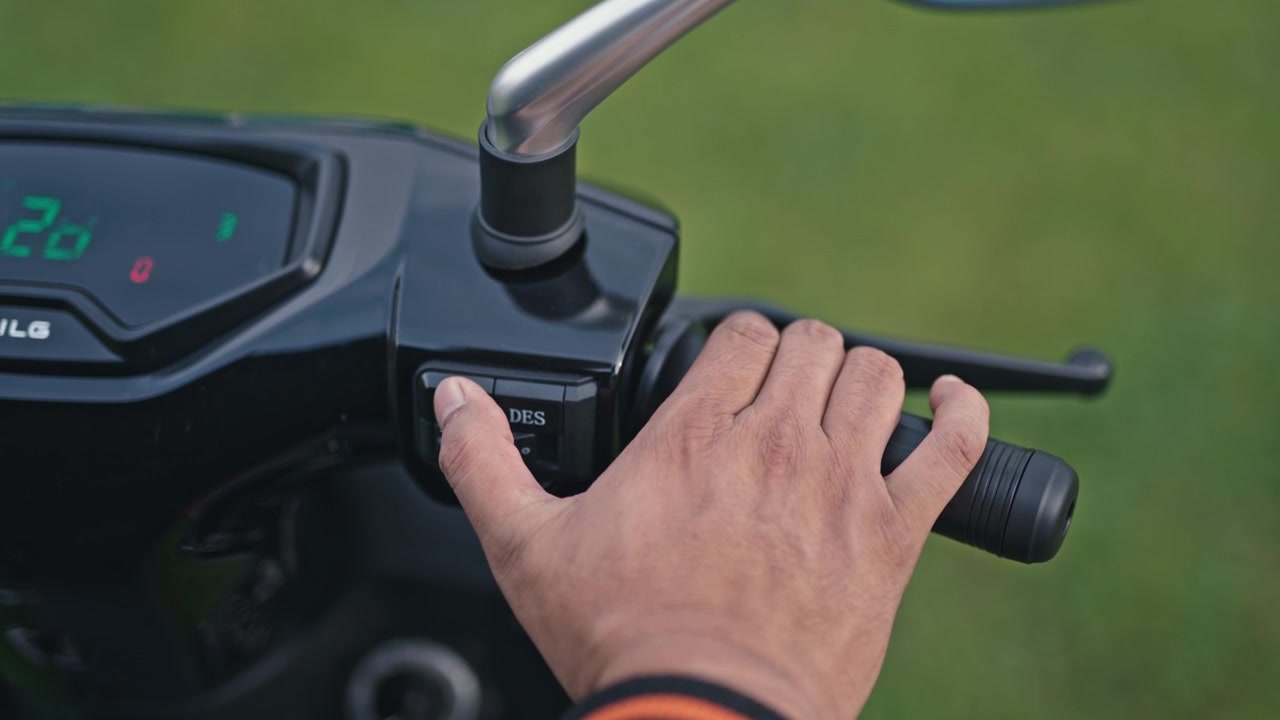 Gros plan sur l'interrupteur d'alimentation d'une trottinette électrique allumé et éteint, montrant l'interface de contrôle et l'interaction utilisateur dans la mobilité moderne