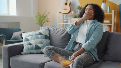 teenager watching tv and eating chips