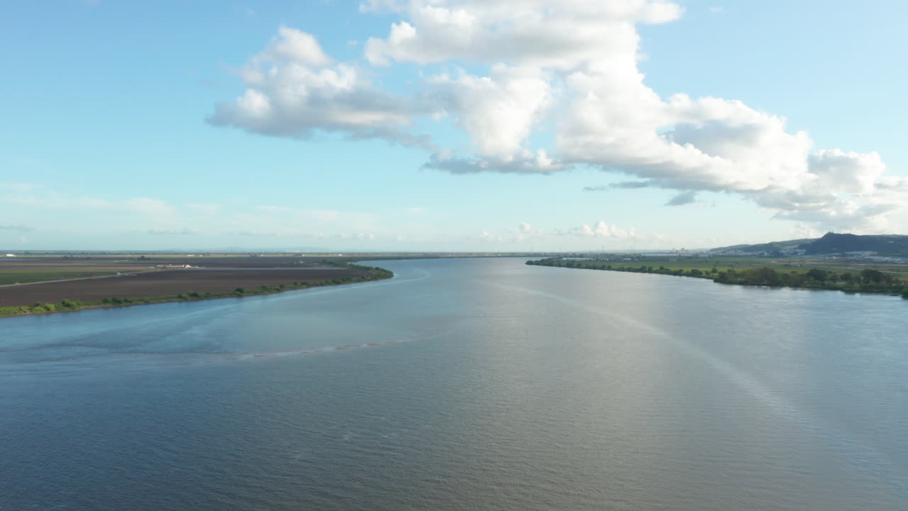 Aerial ascending shot over peaceful Tagus river countryside on sunny day , Portugal