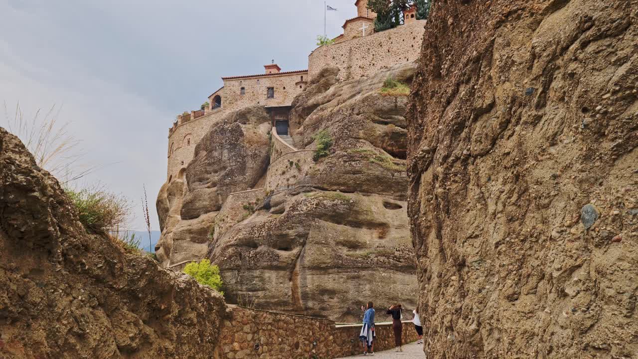 Tourists visit Varlaam Greek monastery Meteora built on vertical cliff
