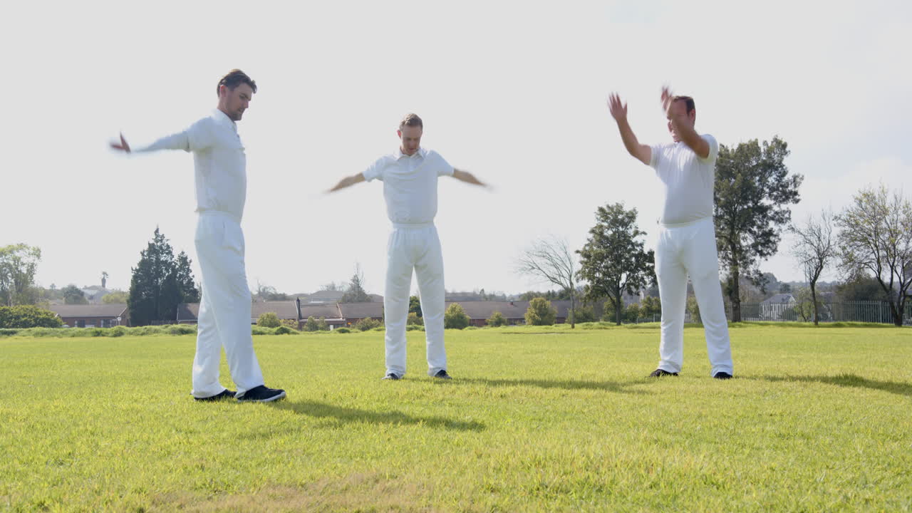 Male cricket players practicing cricket wearing cricket whites on pitch