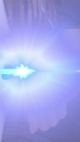 animation of light beam and lens flare over midsection of woman using smartwatch