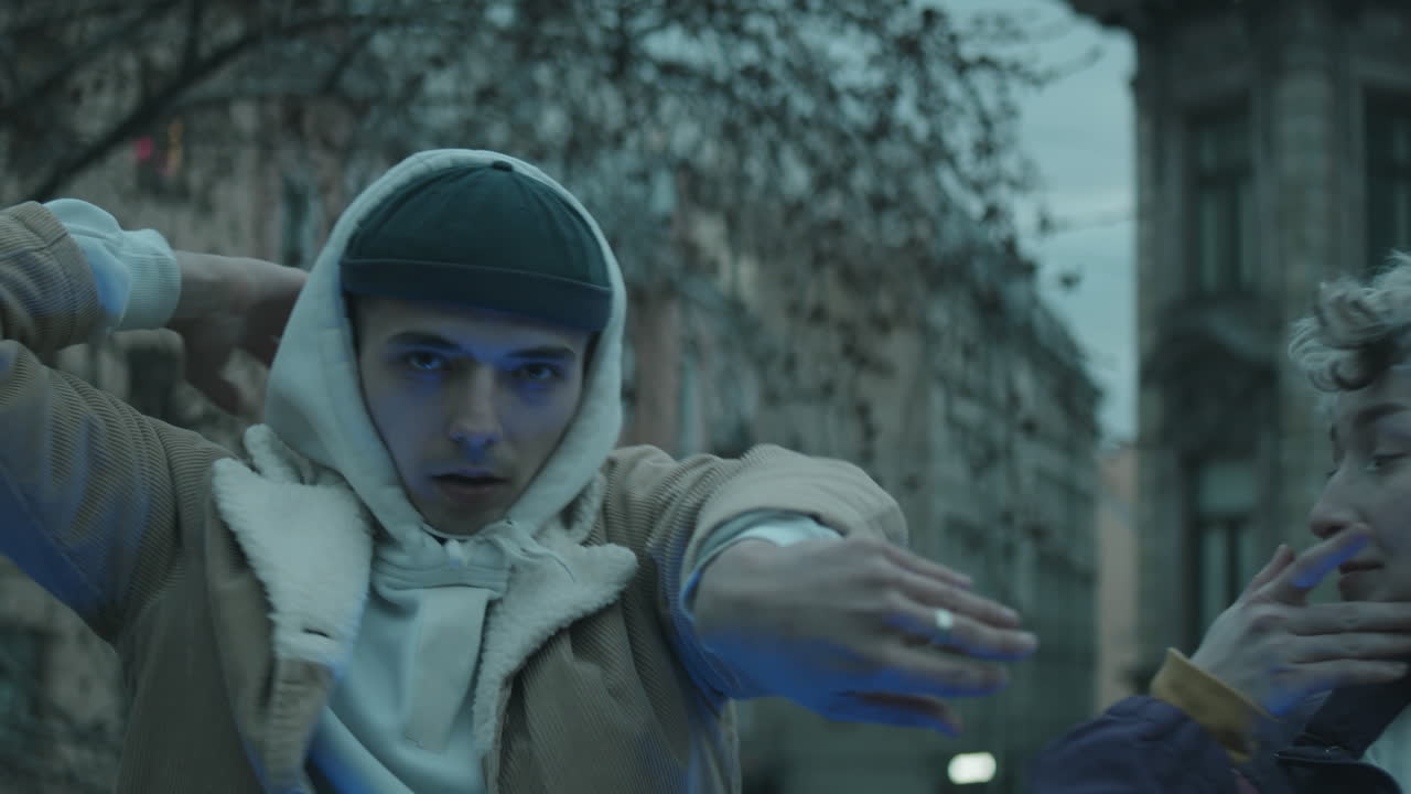 젊은 부부 가 저녁 에 야외 에서 카메라 에게 춤 을 추고 있다