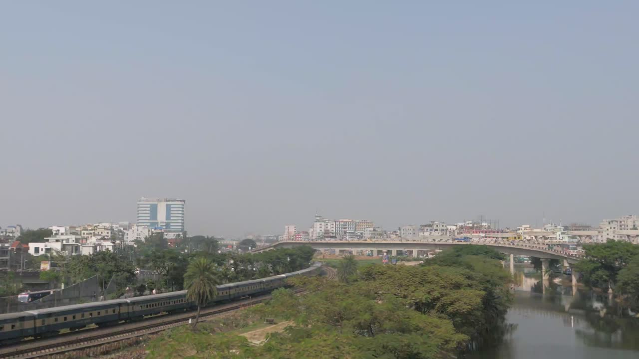 tren pasando por encima de un puente en una ciudad de bangladesh
