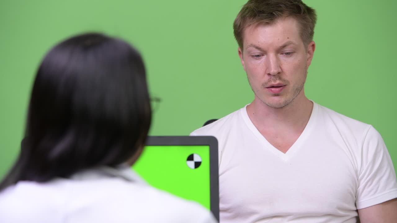 una joven médica asiática da consultas a un paciente joven.