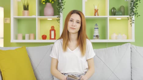 los sueños de la mujer se rompen y ella mira con tristeza su billetera.