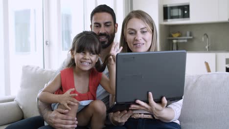 Cheerful-adorable-girl-sitting-on-fathers-lap