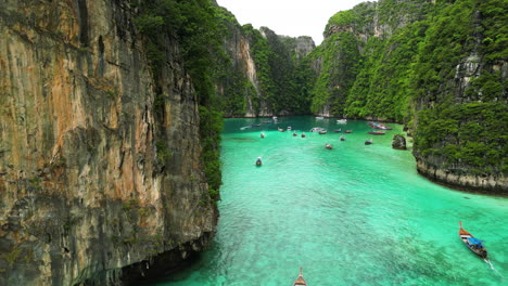 Boats-are-sailing-between-the-mountains-in-Pi-Leh-Bay-,-Phi-Phi-Islands,-Thailand