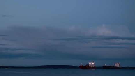 time lapse video of two cargo ships slowly moving at sunset time in fjord