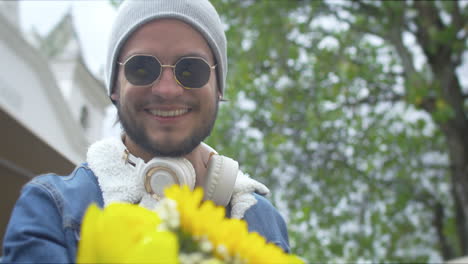 handsome guy buying flowers on the street