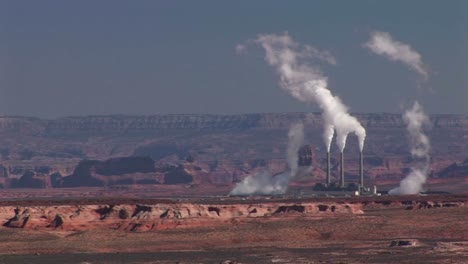 mediumshot of a factory in the arizona desert disgorging pollution