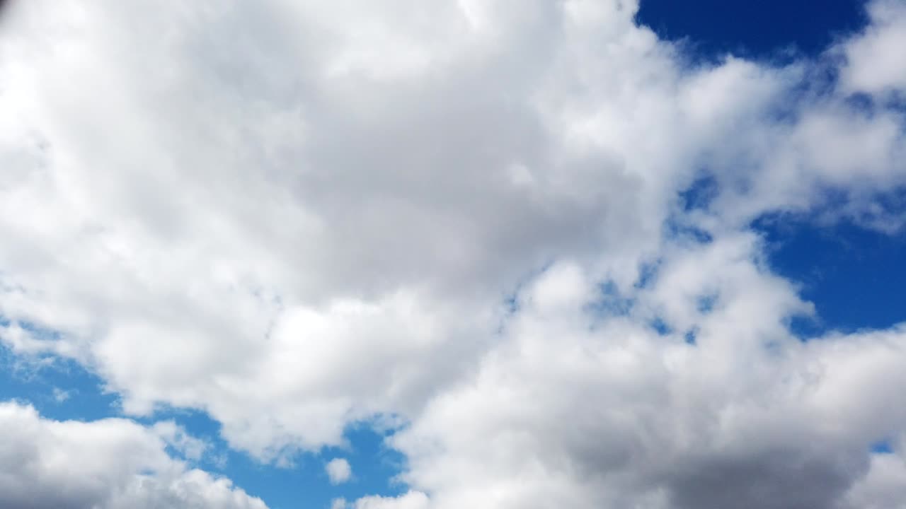Time-lapse of fluffy clouds moving in the blue sky