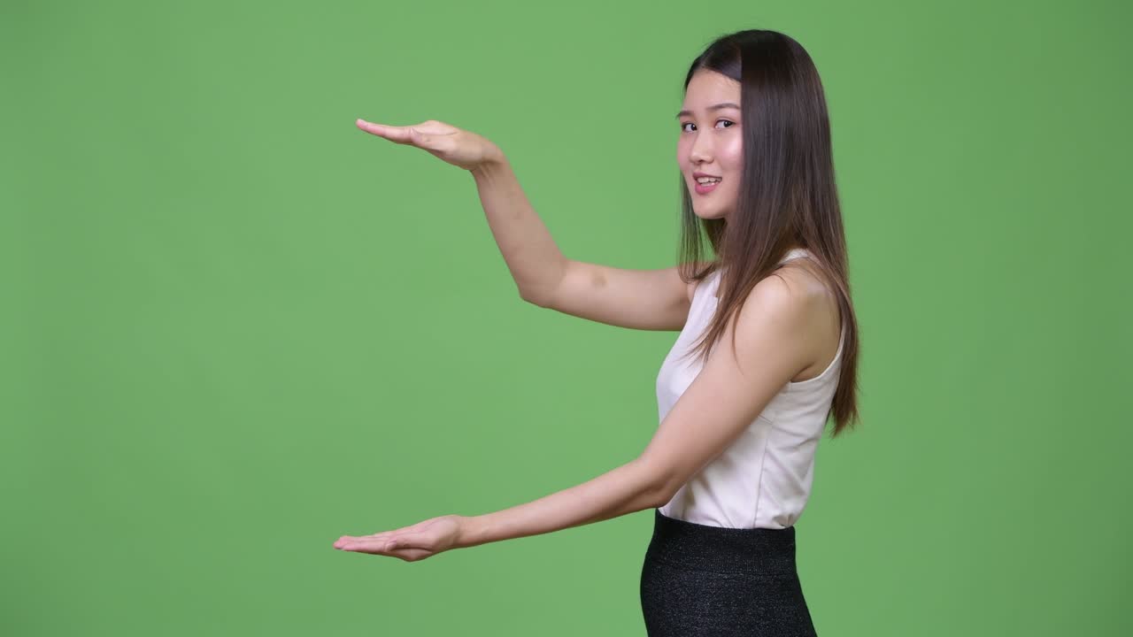 아름다운 젊은 아시아 사업가 여성이 무언가를 보여주고 있습니다.