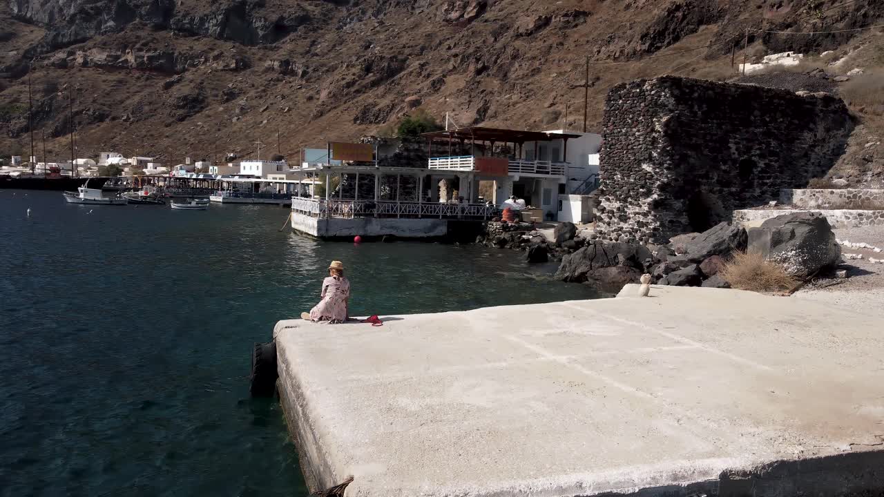 video de drones de una mujer en thirasia port santorini en verano