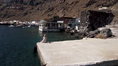 Drone-video-of-a-woman-at-Thirasia-port-Santorini-in-summer