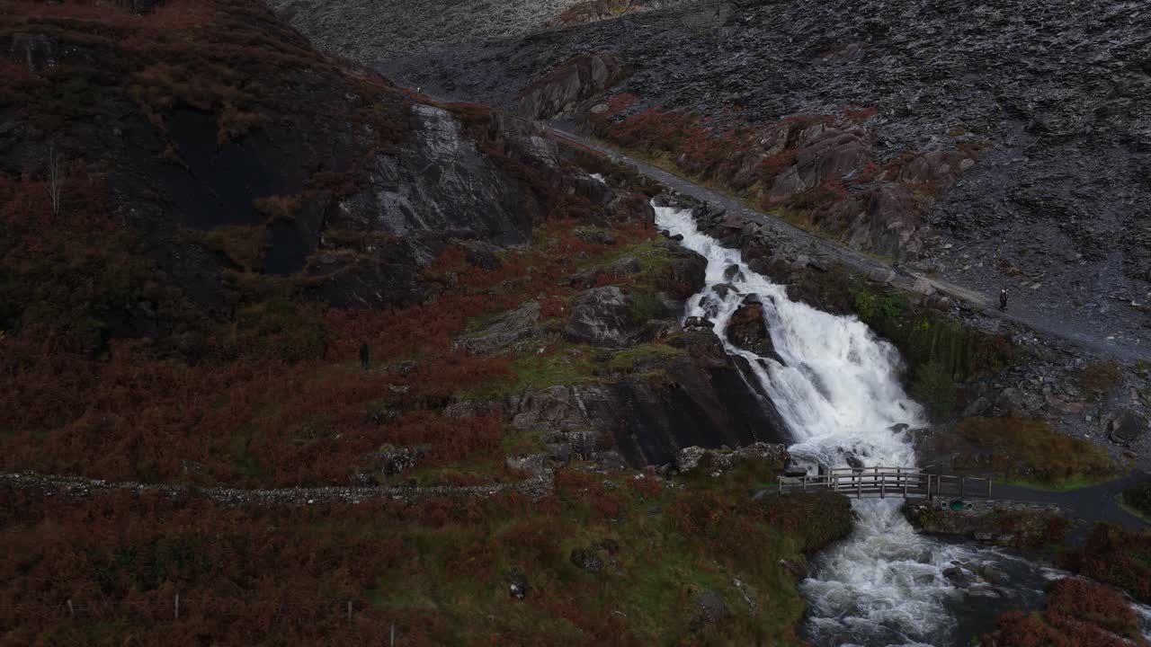 Aerial video of the Cwmorthin Waterfall at the historic Cwmorthin Quarry in Snowdonia National Park, showcasing rugged Welsh terrain, cascading water, and dramatic natural scenery
