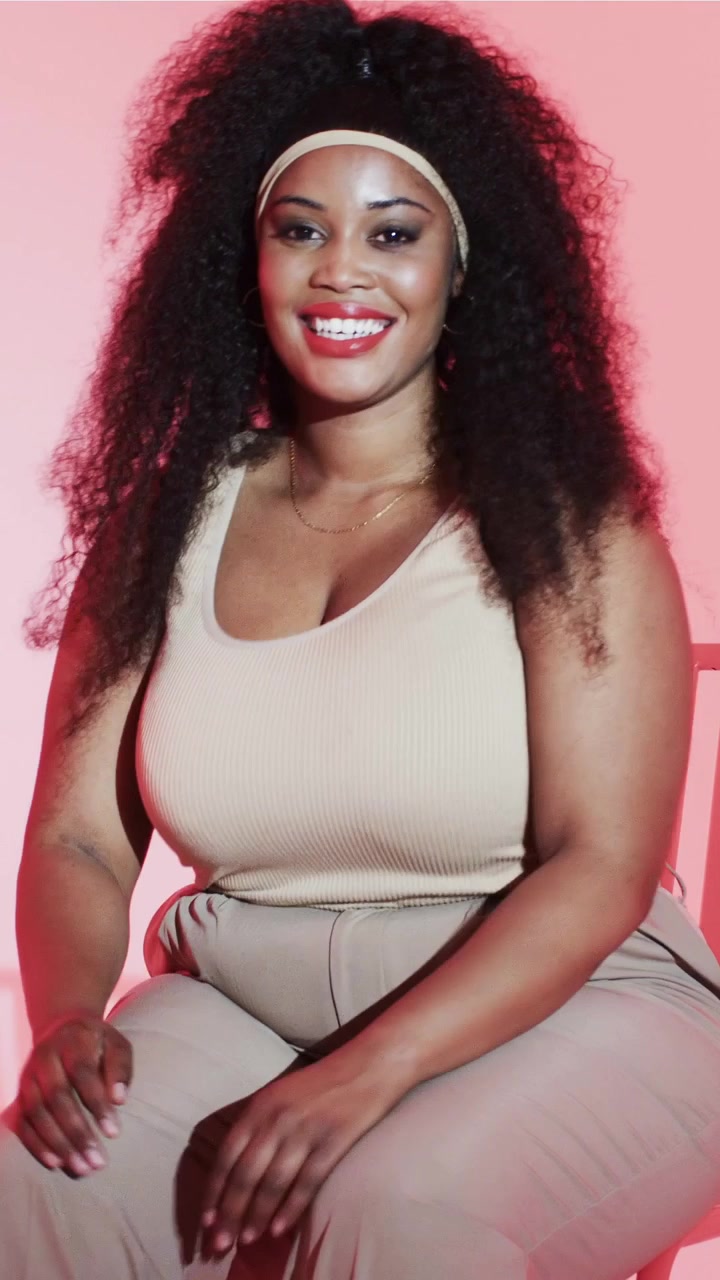 Vertical video: Starting gaze, woman touching chin, smiling laughing posing, tan top, studio