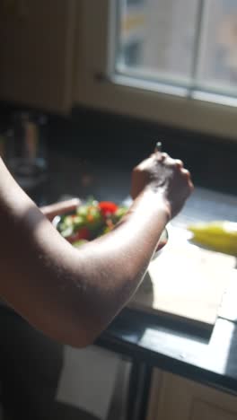mujer preparando una ensalada en una cocina
