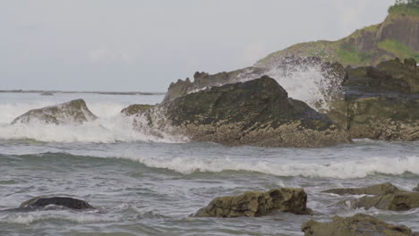 waves crashing on rocks on a beach in myanmar